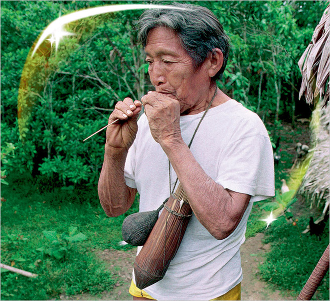 Амазонский индеец племени ягуа с духовой трубкой во рту