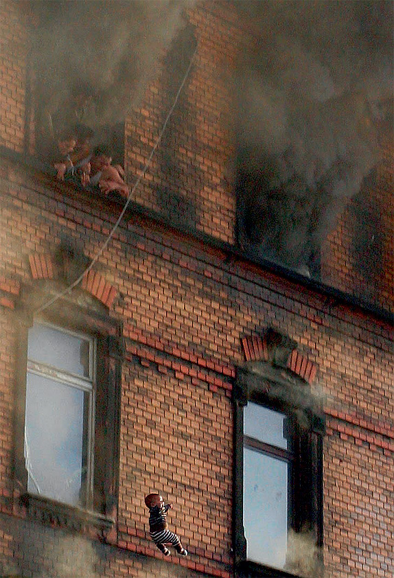 Ребенка выбросили из горящего здания